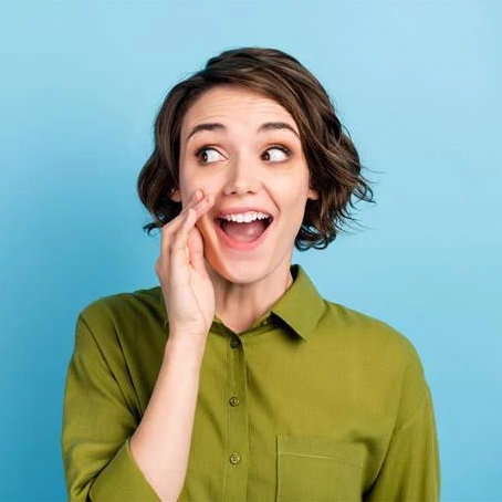 Une femme avec une chemise verte qui cache sa bouche de côté